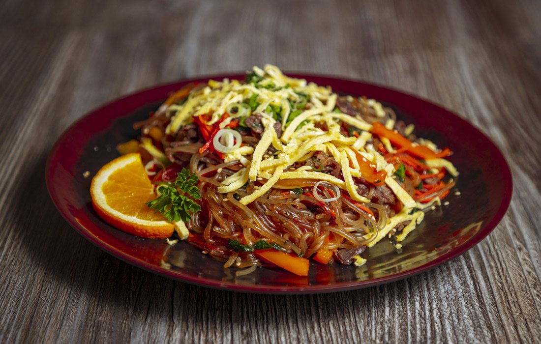 A plate of Koriya's japchae, a sweet-and-savory dish featuring noodles, beef bulgogi and vegetables