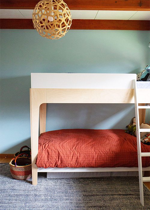 light blue green accent wall with salmon colored bedding