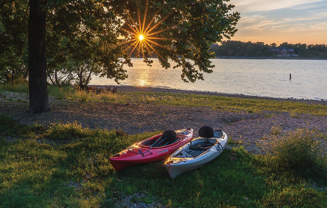 Kayaks on the side of a lake.