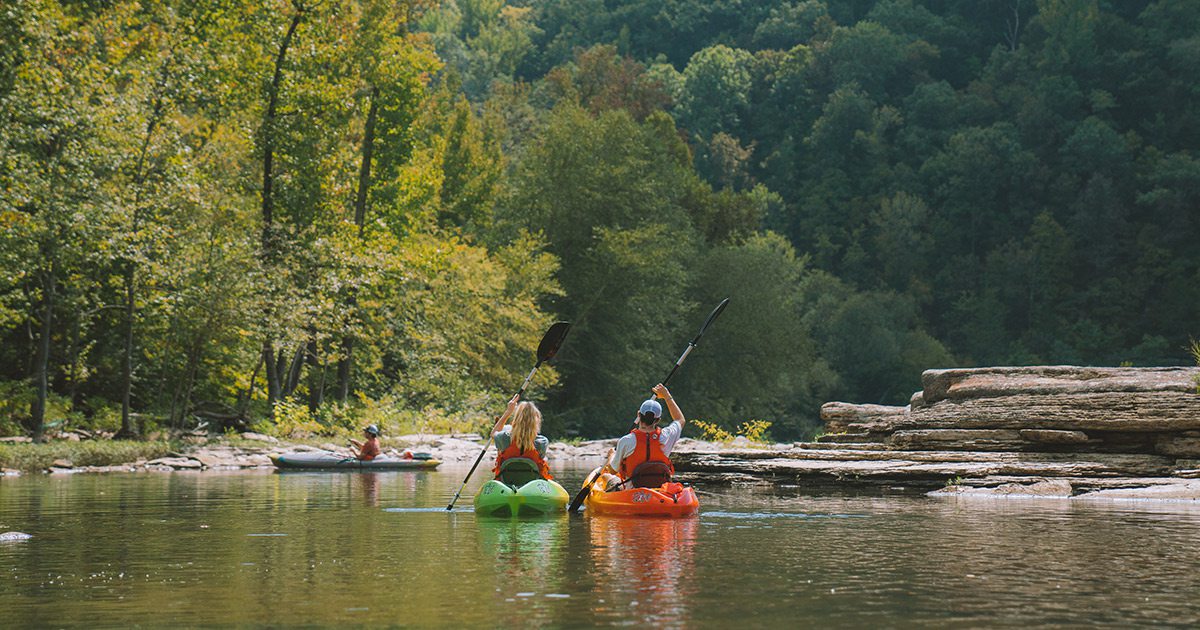 Couple floating in kayaks on the Mulberry River in Arkansas