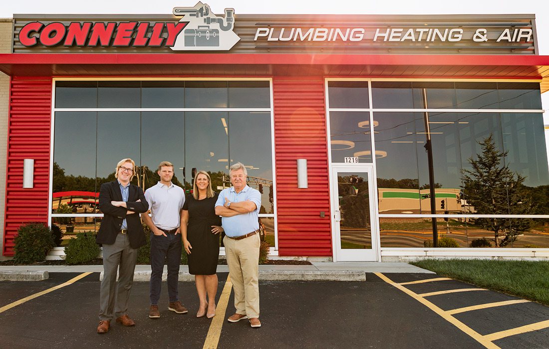 Connelly Plumbing owners stand in front of building