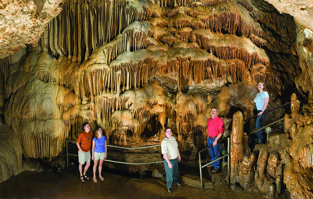 Five people stand in a cavern.
