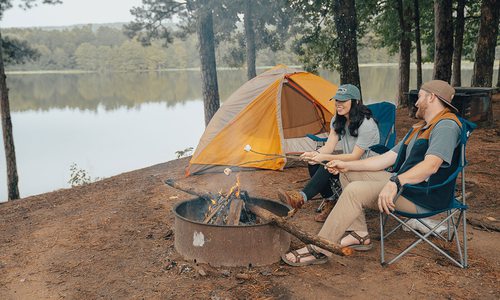young couple roasting marshmallows over a campfire