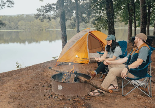 young couple roasting marshmallows over a campfire