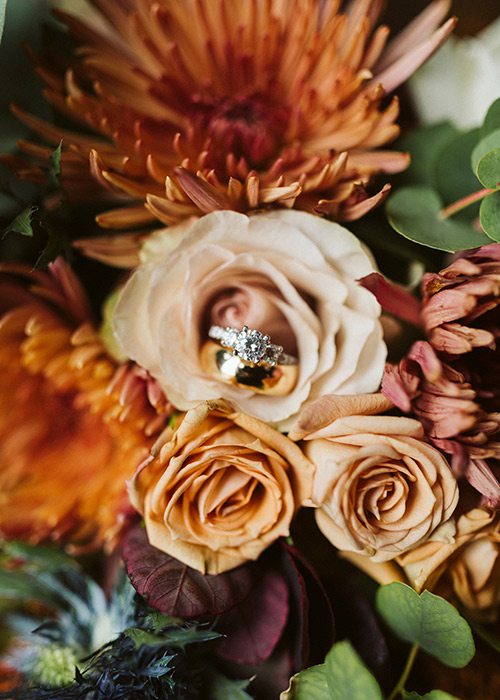 Cheyann Weinacht's wedding ring in her fall colored wedding flowers