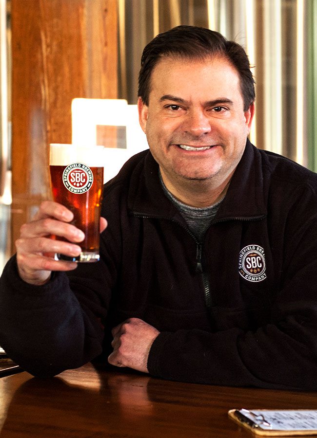 Springfield Brew Co head brewery Ashton Lewis holding a glass of craft beer