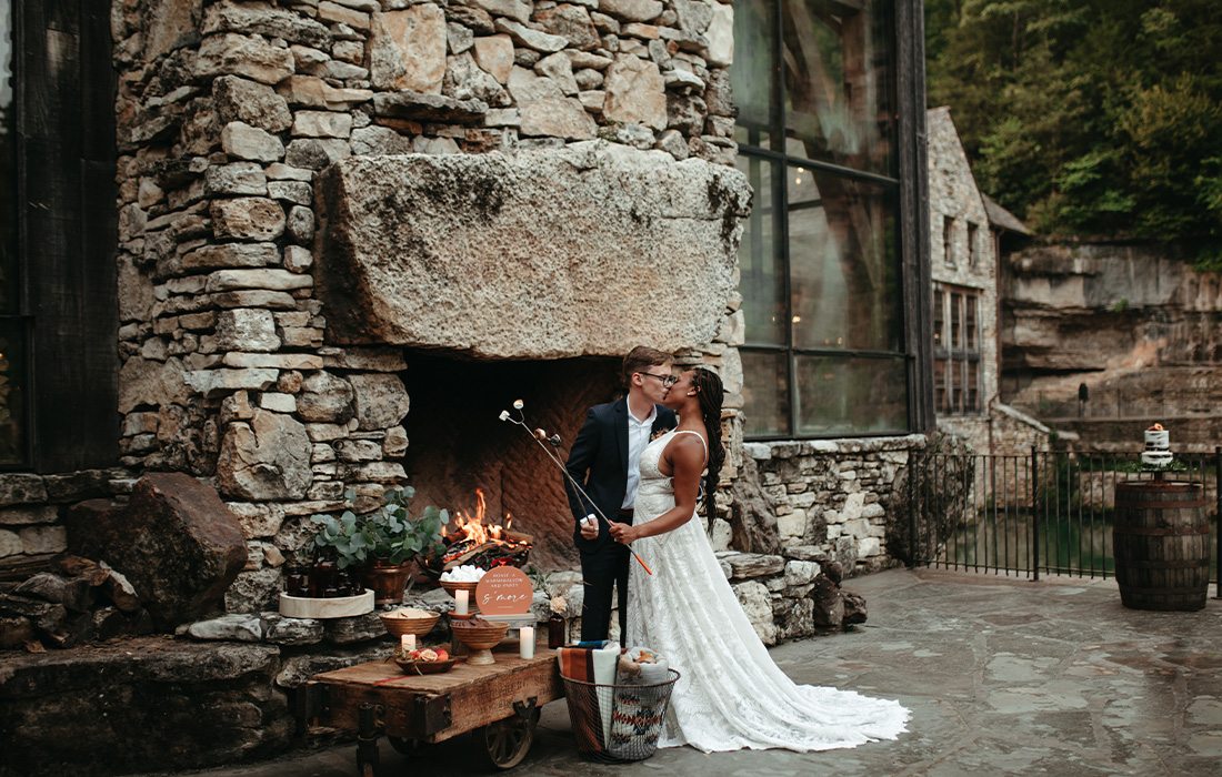 Bride and groom enjoying s'mores at Dogwood Canyon.