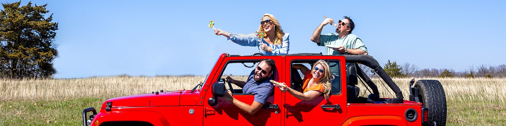 People riding in red jeep outdoors