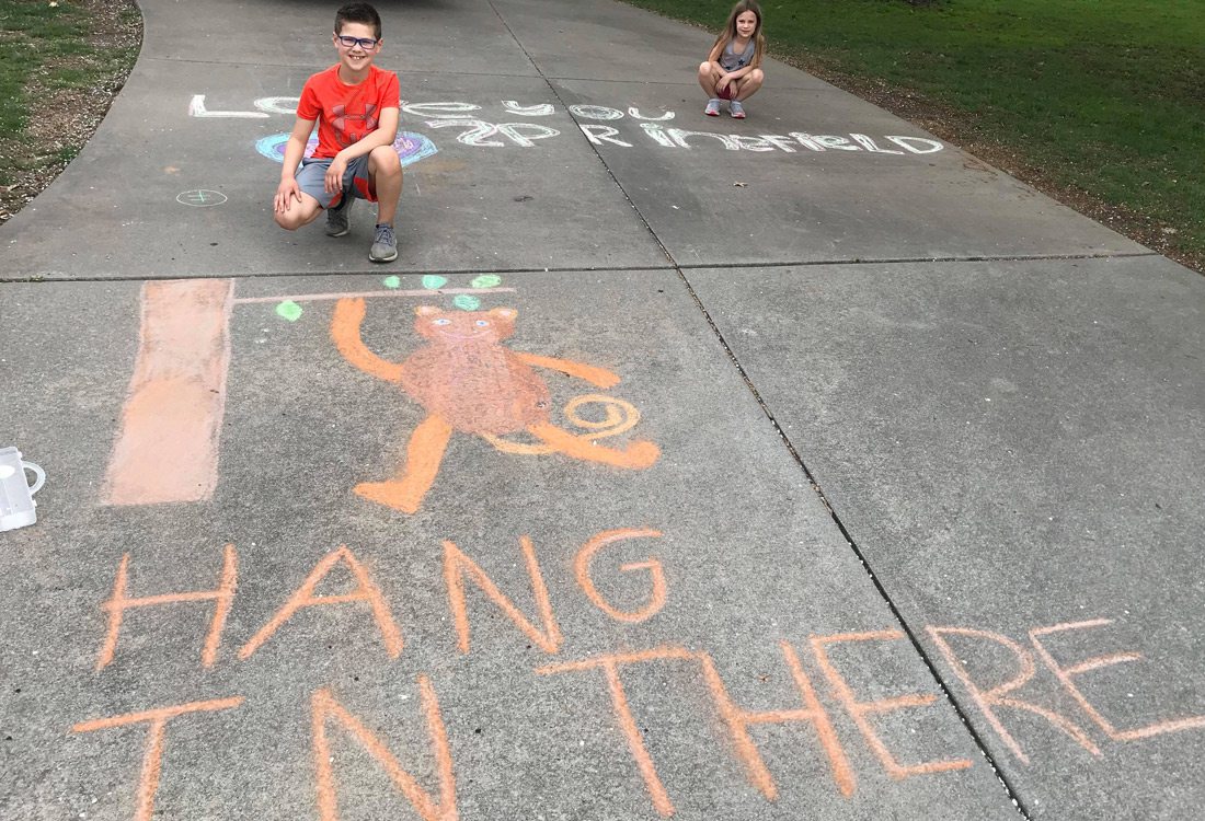 Ryland Matthews and Elise Matthews chalk messages in Emerald Park