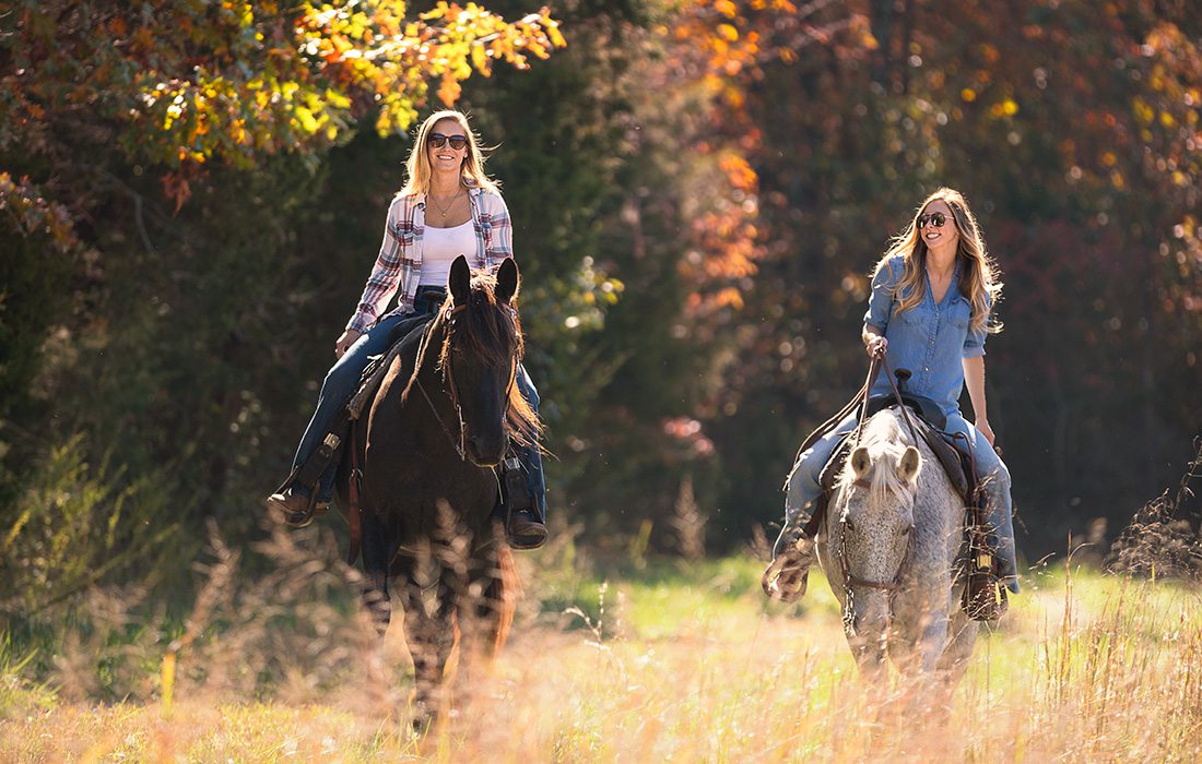 two women horseback riding