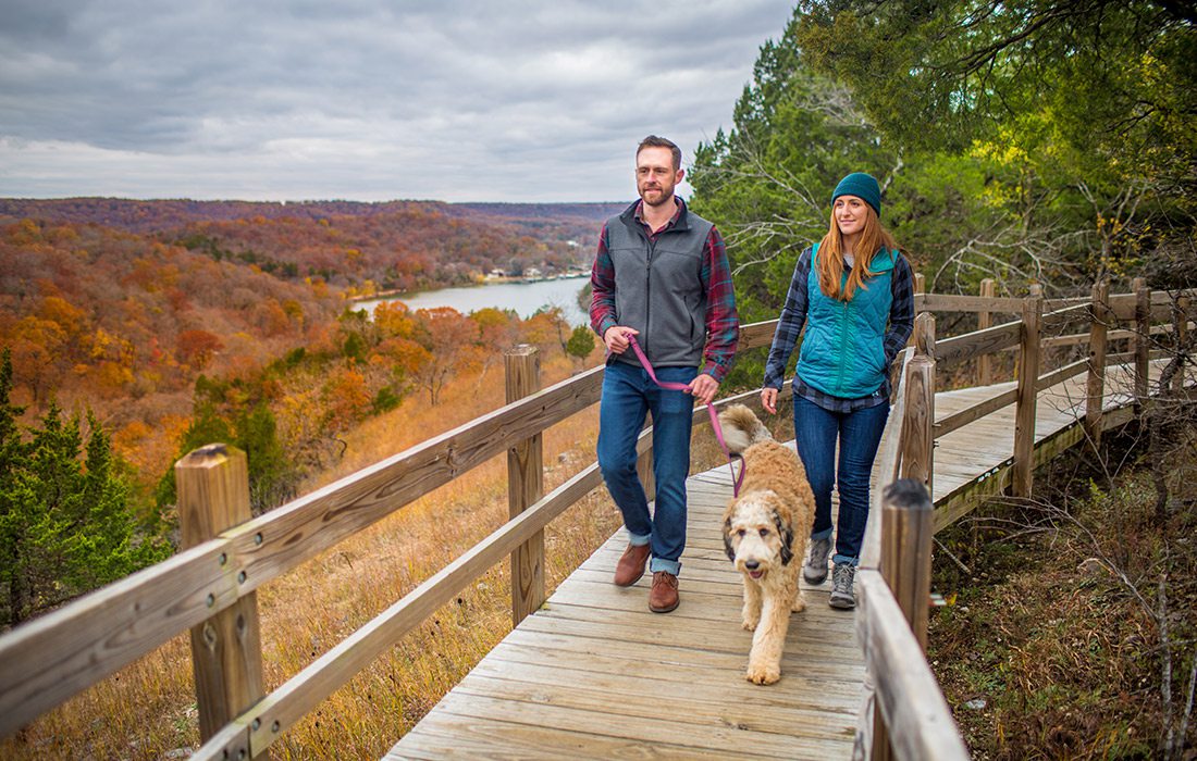 Young couple walking their dog on the Ha Ha Tonka loop trail in Camdenton, Missouri