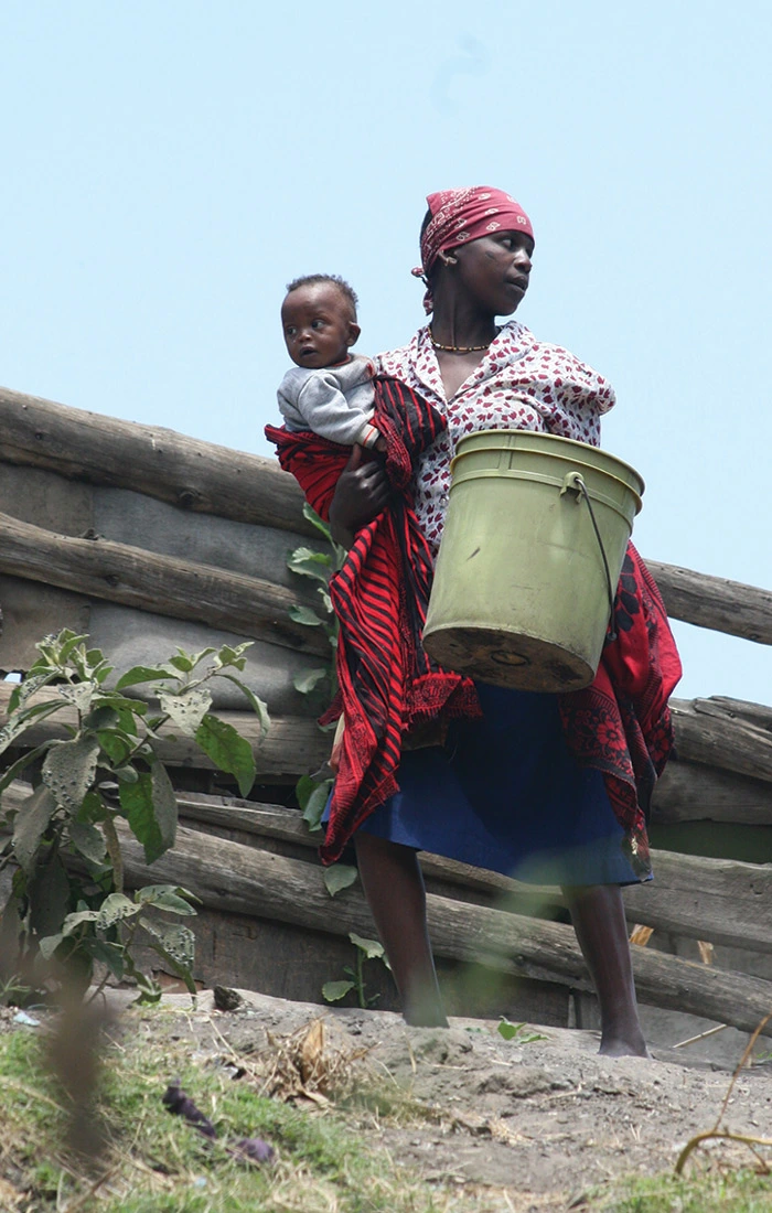 Woman with baby and bucket of water