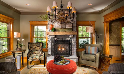 grand, ornate fireplace framed by open windows and plush chairs