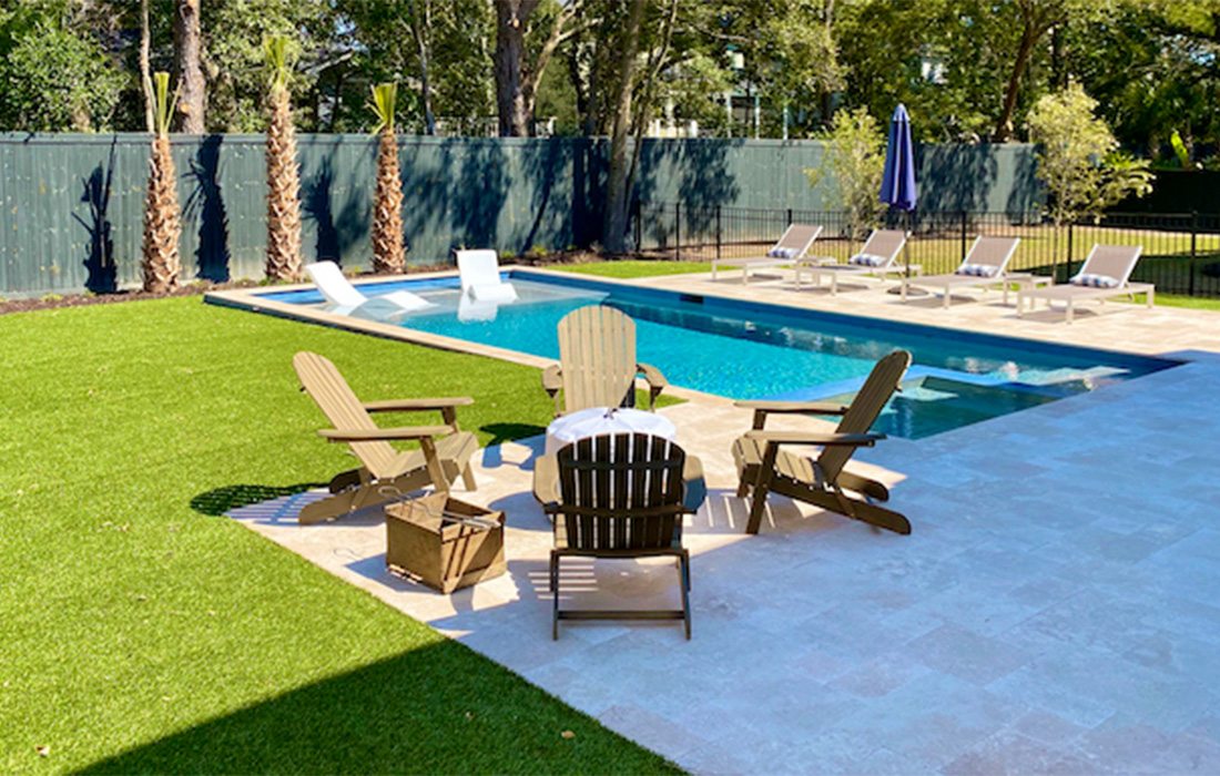 The evergreen turf next to the pristine pool brings a resort-level style of relaxation to your backyard.