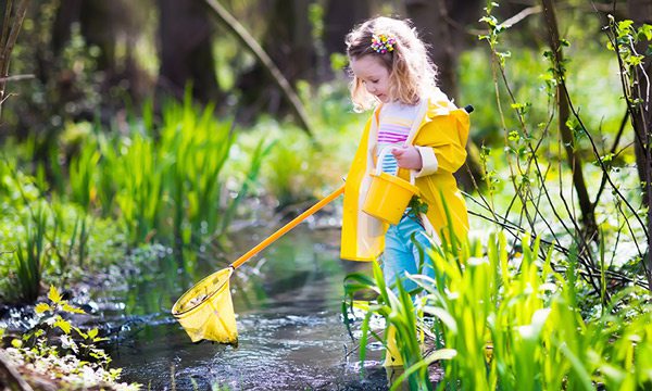 Girl fishes in yellow raincoat
