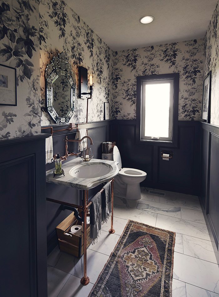 Copper sink in navy and floral bathroom with wallpaper by Adrian Rhoads.