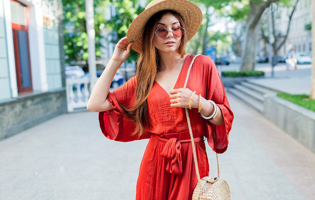 Young woman wearing a red jumpsuit and a straw hat