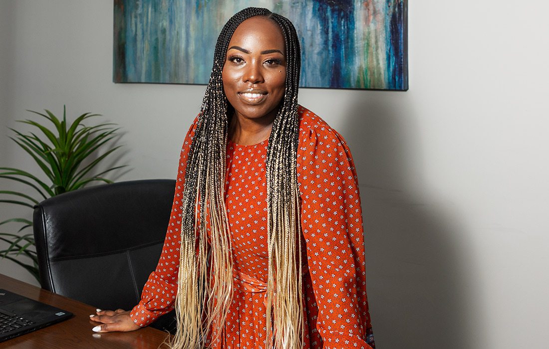 Celestine Copeland stands in front of desk