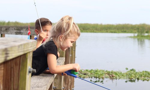 Two kids fishing off dock