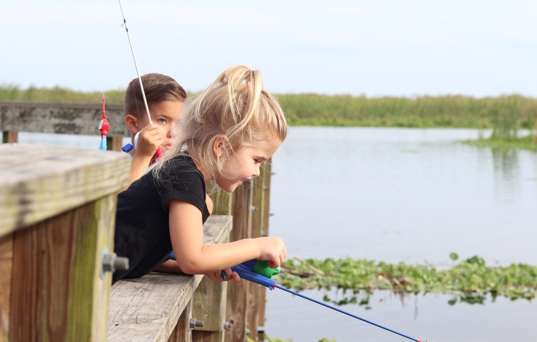 Two kids fishing off dock