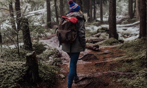 Woman hiking in the woods during winter.