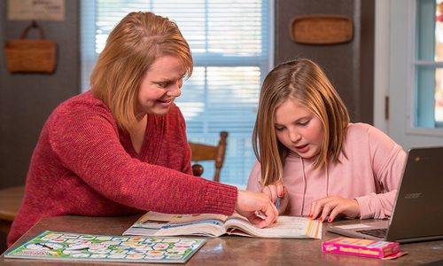 Woman tutoring a young girl