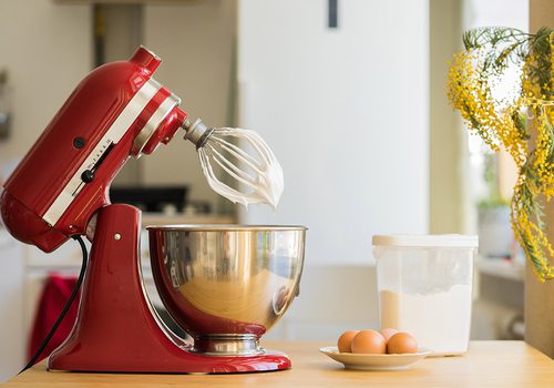 Red KitchenAid stand mixer in a bright white kitchen