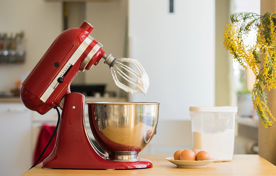 Red KitchenAid stand mixer in a bright white kitchen