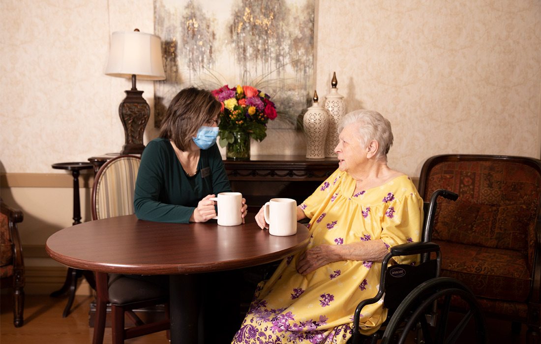 Shana Parker (LNHA) of Magnolia Square Nursing and Rehab enjoys coffee with a resident.