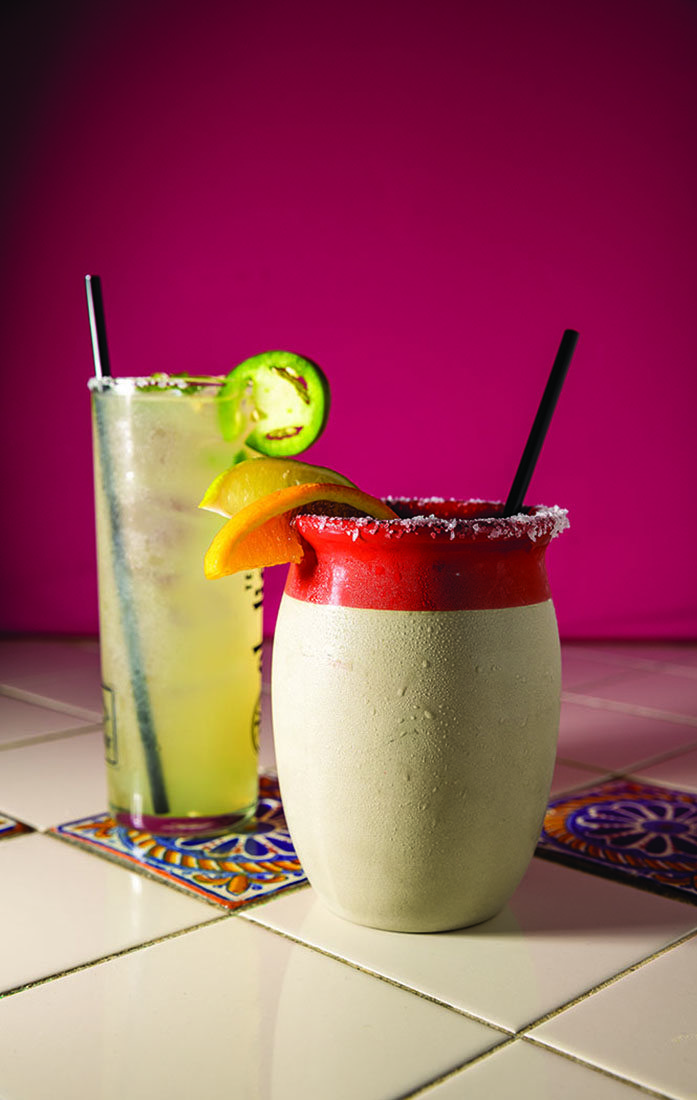 A cocktail and a margarita in decorative, salted glasses.