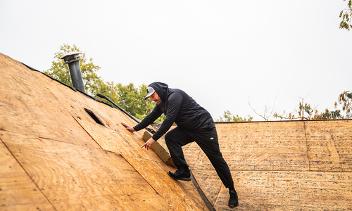 Midwest Roofing team member inspecting roof decking during a roof replacement project to ensure proper structural support and long-term performance.