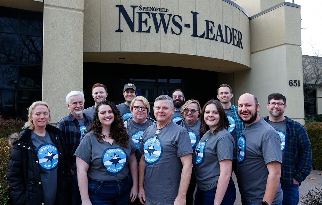 The news staff in front of their building