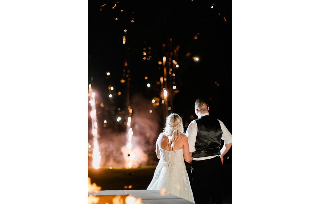 Bride and Groom looking on at a firework show.