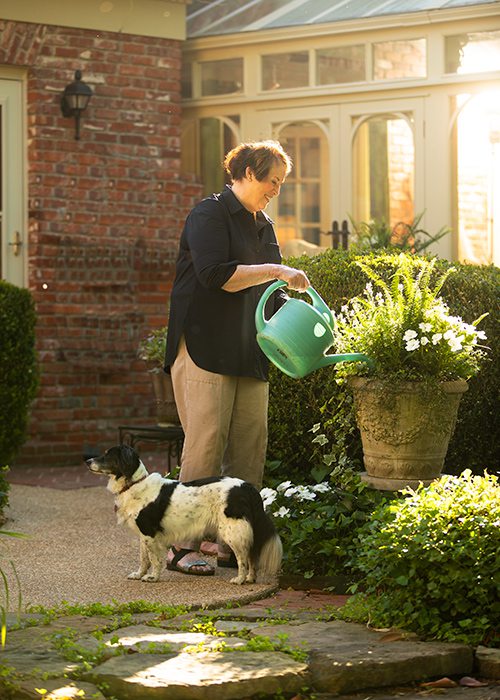 Peg Carolla watering in her backyard garden