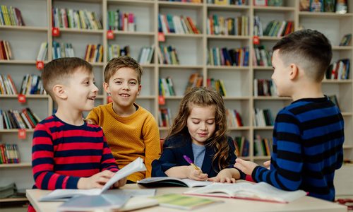 Kids reading and working around a table