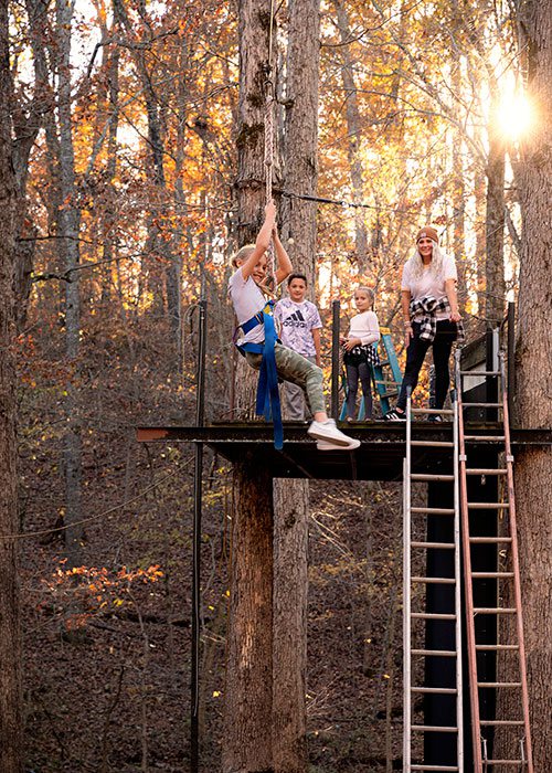 Family watching girl zipline