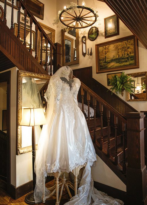 Wedding dress on display in front of staircase.