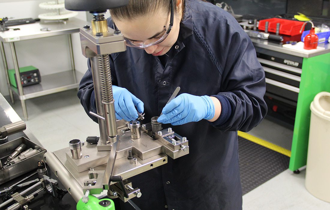 A technician assembles a high pressure common rail fuel injector