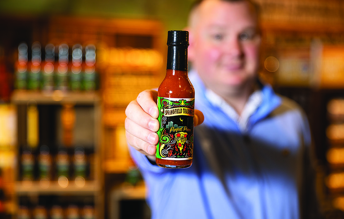Brent displays a bottle of his hot sauce.