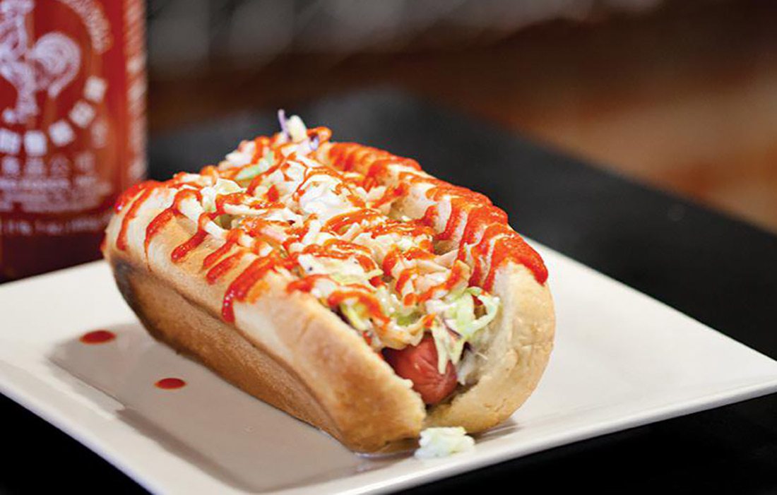 Hot dog with piles of toppings at Instant Karma in Joplin MO