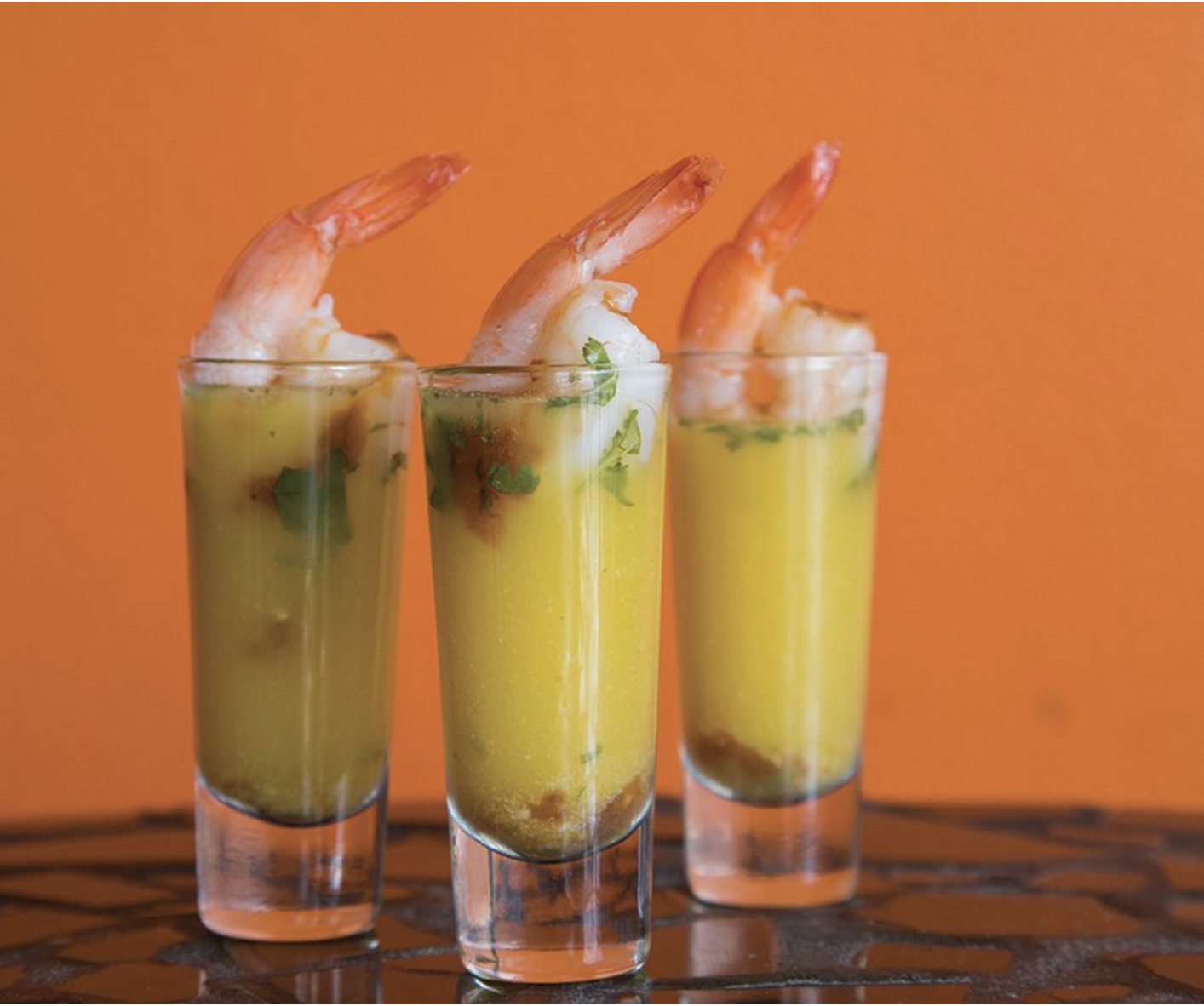 Colorful shrimp appetizer with ceviche juice and hot chili sauce in a shot glass from a Peruvian restaurant