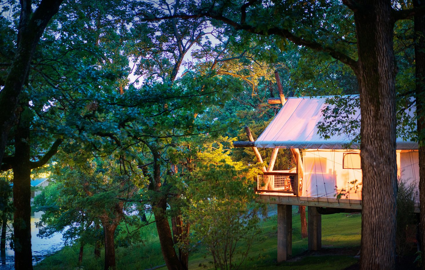 A glamping yurt sitting in green natural surroundings