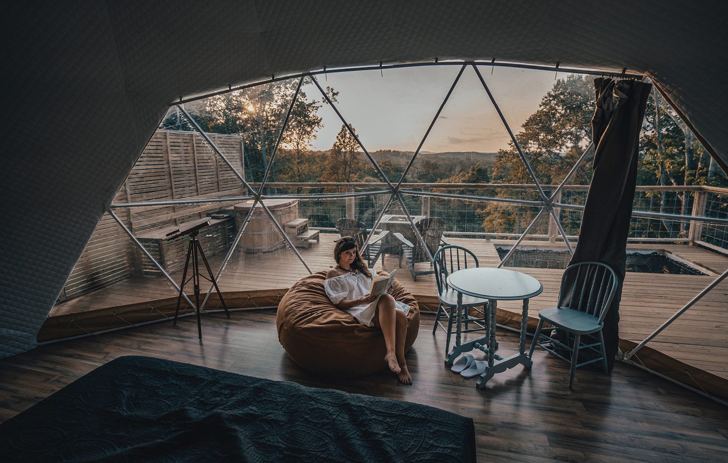 A woman sitting inside a glamping tent with a beautiful view outside