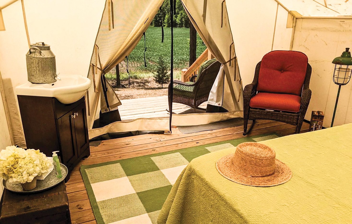 Interior of a luxury yurt with a rug, furniture, table and a door leading to the outdoors