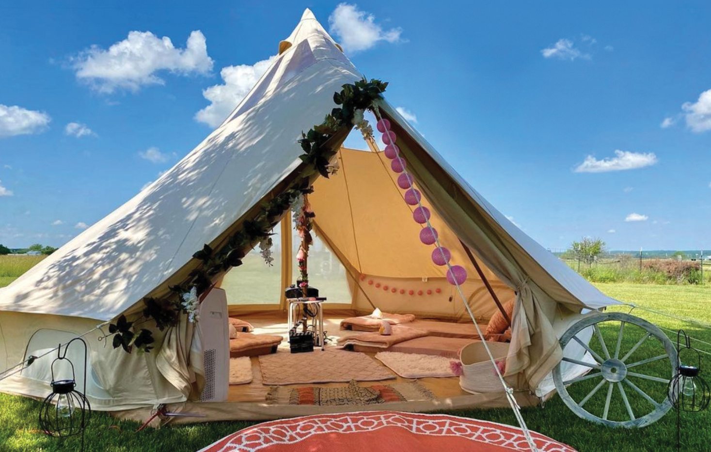 A bright, airy yurt in an open field with a bright blue sky in the background