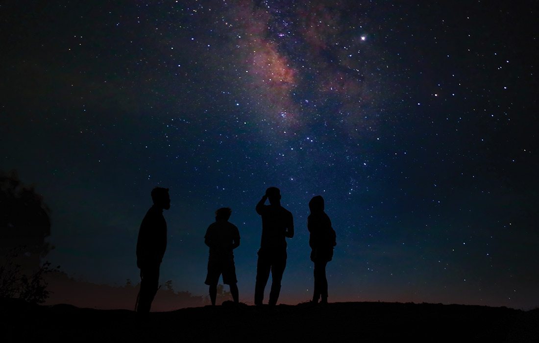 Stock photo of a group of people stargazing at night