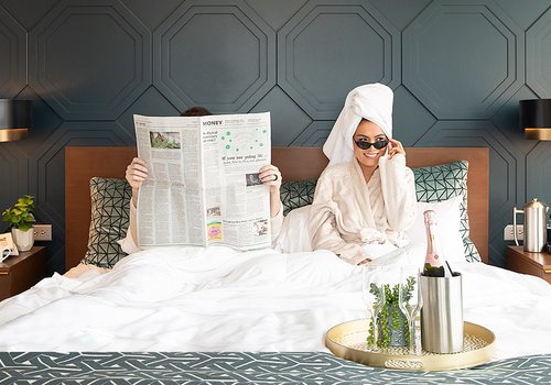 Couple lounging in bed at Hotel Vandivort in Springfield, MO