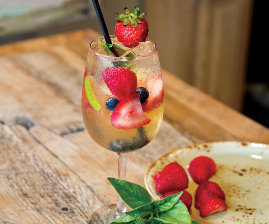 Berry peach sangria on wooden table.