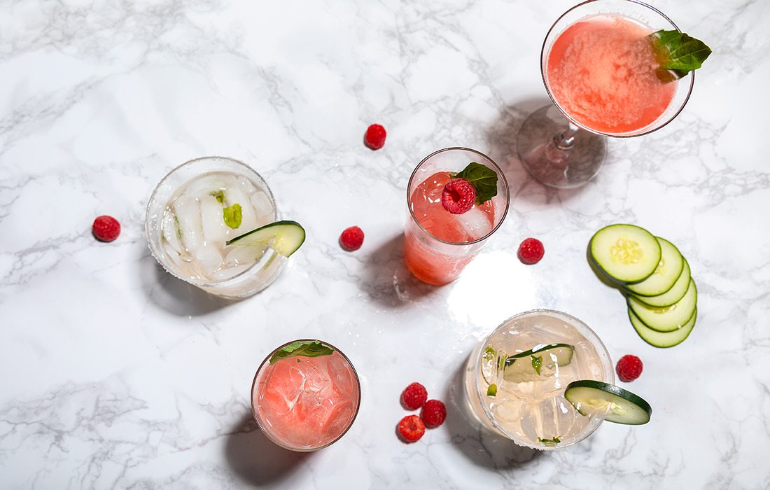 Summer cocktails with ingredients on marble counter