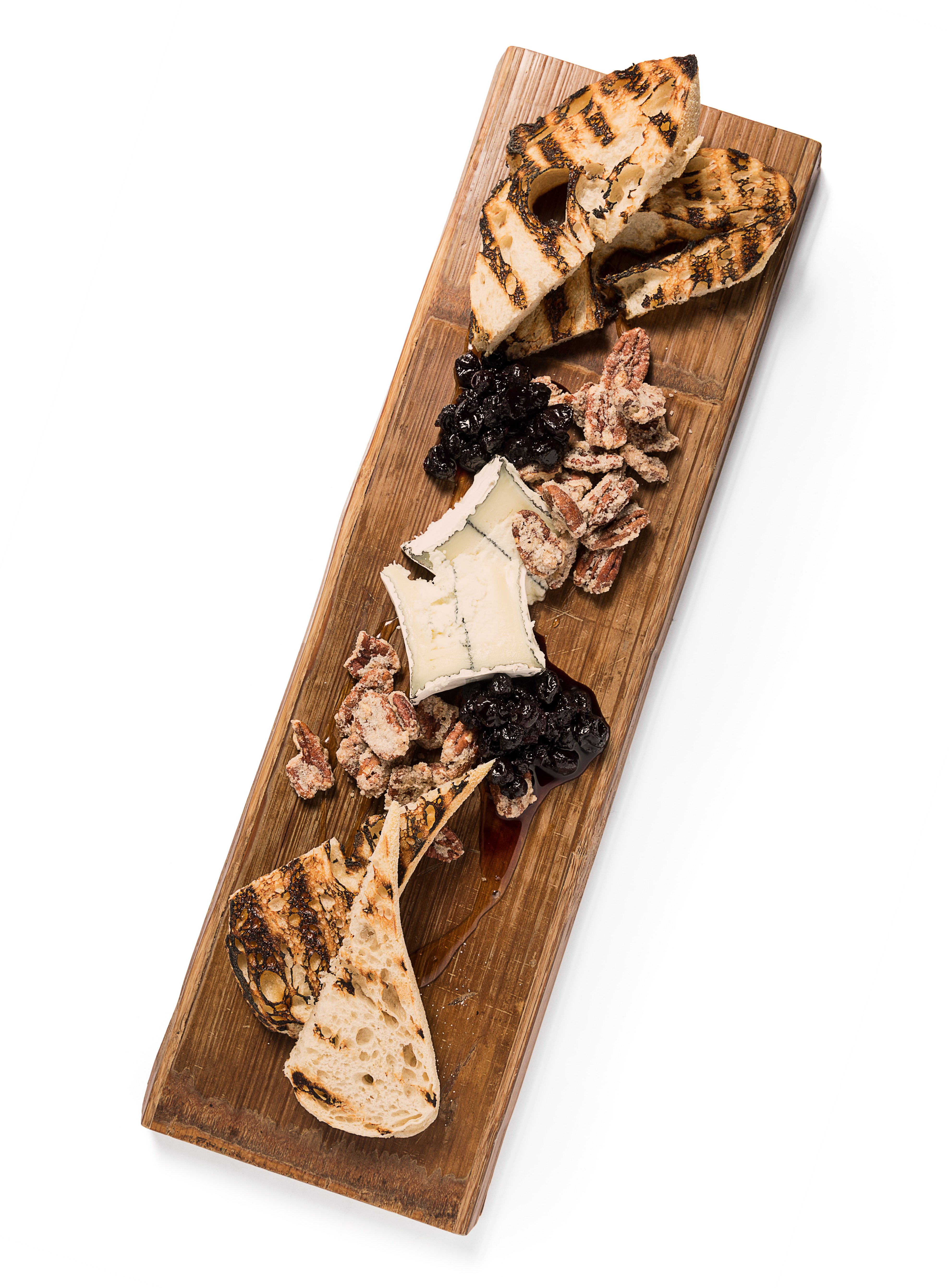 Grilled sourdough, blueberry chutney and honey encircle the cheese board’s centerpiece: Humboldt Fog Goat Cheese.